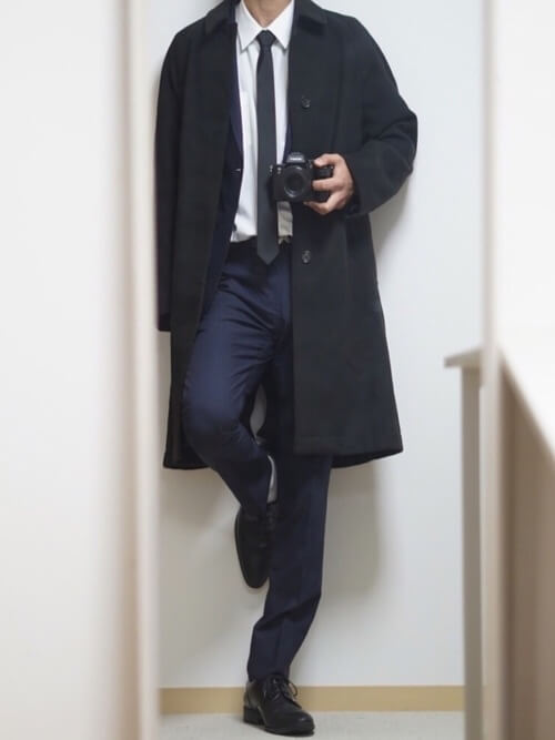 ステンカラーコート×ネイビーのスーツ×白のシャツ×黒のネクタイ×黒のブーツ