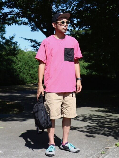 ピンクのTシャツ×ベージュのショートパンツ×グレーのスニーカー